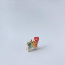 Very small ceramic sculpture of a tiger with a white underbelly and rainbow coloring on its back with gold detailing.