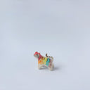 Very small ceramic sculpture of a tiger with a white underbelly and rainbow coloring on its back with gold detailing.