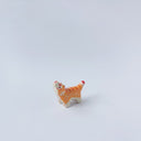 Very small ceramic sculpture of a tiger with a white underbelly and orange fur with red stripes, gold detailing and white carved poppy flowers. It is in a roaring stance.