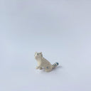 Very small glossy ceramic sculpture of a white tiger with blue stripes and subtle gold detailing.