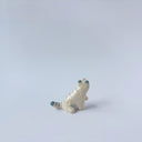 Very small glossy ceramic sculpture of a white tiger with blue stripes and subtle gold detailing.
