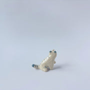 Very small glossy ceramic sculpture of a white tiger with blue stripes and subtle gold detailing.