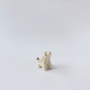 Very small glossy ceramic tiger sculpture, white with gold stripes and golden poppy flower design on its fur. It sits with a cute, happy expression.