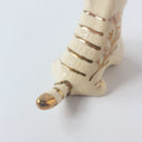 Very small glossy ceramic tiger sculpture, white with gold stripes and golden poppy flower design on its fur. It sits with a cute, happy expression.