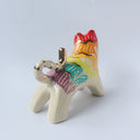 Glossy ceramic sculpture of a tiger with a white underbelly and rainbow coloring on its back with gold detailing.