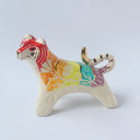 Glossy ceramic sculpture of a tiger with a white underbelly and rainbow coloring on its back with gold detailing.
