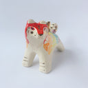 Glossy ceramic sculpture of a tiger with a white underbelly and rainbow coloring on its back with gold detailing.