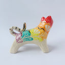 Glossy ceramic sculpture of a tiger with a white underbelly and rainbow coloring on its back with gold detailing.