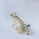 Glossy ceramic sculpture of a white tiger with blue stripes and subtle gold detailing.