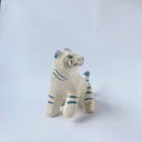 Glossy ceramic sculpture of a white tiger with blue stripes and subtle gold detailing.