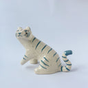 Glossy ceramic sculpture of a white tiger with blue stripes and subtle gold detailing.