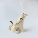 Glossy ceramic tiger sculpture, white with gold stripes and golden poppy flower design on its fur. It sits with a cute, happy expression.