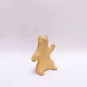 A brown clay sculpture of a bear, sitting on its hind legs, waving. It has subtle carved fur texture.