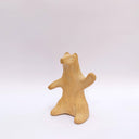 A brown clay sculpture of a bear, sitting on its hind legs, waving. It has subtle carved fur texture.