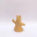 A brown clay sculpture of a bear, sitting on its hind legs, waving. It has subtle carved fur texture.