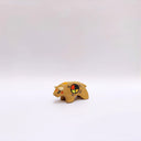 Small ceramic sculpture of a brown bison with 2 cream colored horns, red cheeks and a circular multicolor emblem on its side.