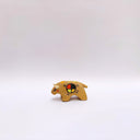 Small ceramic sculpture of a brown bison with 2 cream colored horns, red cheeks and a circular multicolor emblem on its side.