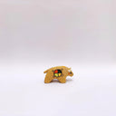 Small ceramic sculpture of a brown bison with 2 cream colored horns, red cheeks and a circular multicolor emblem on its side.