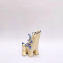 Cream colored ceramic sculpture of a wolf, with a blue crescent moon on its back and floral blue artwork on its body.