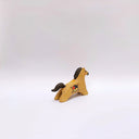 A small ceramic horse figurine in its natural brown clay coloring, decorated with black painted stripes on its mane and tail, and a circular multicolor emblem on its side, set against a plain light gray background.