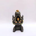 Ceramic figurine of a black bear, with its arms cradling 2 small animals - a miniature deer and a miniature buffalo. The bear has 2 ravens on its shoulders and a gold coin atop its head.