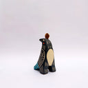 Ceramic sculpture of a black bird, with sgraffito wing patterning to reveal a cream colored clay, with blue and orange color detailing. It has a poppy flower on its back and a coin atop its head.