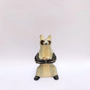 Ceramic sculpture of a cream and gray fox with black accent colorings, sitting up on its hind legs with its arms together in a cradling pose. Resting in its arms is a small wrapped doll.