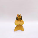 Beige ceramic sculpture of a lion/bear animal, sitting up on its hind legs, with its arms cradled together. There is a recession in its chest. It has subtle poppy flower designs on it.