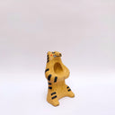 Beige ceramic sculpture of a wolf/tiger animal, sitting up on its hind legs, with its arms cradled together. There is a recession in its chest. It has subtle poppy flower designs on it.