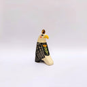 Ceramic sculpture of a bald eagle, looking to the side. Its wings are black and cream and it has a poppy flower art on its back. It has a gold coin atop its head.