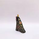 Ceramic sculpture of a black raven-like bird, with sgraffito line art, cream and red, on its feathers. It has a gold coin atop its head and a small key on a red string in its beak.