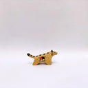 Small ceramic sculpture of a brown tiger, with black stripes on its back and tail and a circular 4-colored emblem on its side.