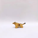 Small ceramic sculpture of a brown tiger, with black stripes on its back and tail and a circular 4-colored emblem on its side.