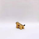 Small ceramic sculpture of a brown tiger, with black stripes on its back and tail and a circular 4-colored emblem on its side.