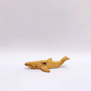 Small ceramic sculpture of a whale, with a long mouth and a circular 4-color emblem on the side of its body.