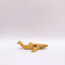Small ceramic sculpture of a whale, with a long mouth and a circular 4-color emblem on the side of its body.