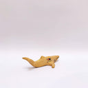 Small ceramic sculpture of a whale, with a long mouth and a circular 4-color emblem on the side of its body.