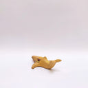 Small ceramic sculpture of a whale, with a long mouth and a circular 4-color emblem on the side of its body.