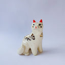 White ceramic figurine of a fox or cat with red ears and a gold leaf pattern on its body of poppy flowers and leaves.