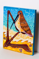 Painting of a stylized sand piper on a beach, with very large legs that are bent over as if kneeling. 