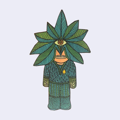 Die cut wooden sculpture of a person wearing knit clothes with monster heads for gloves. Over its face is a leafy star mask, with a single cyclops eye.