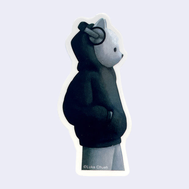 Die cut sticker of a white bear wearing a baggy black hoody and a pair of silver headphones.