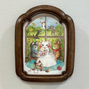 Illustration of 4 cartoon, cute cats having a tea party while sitting at a round white cloth covered table. 3 of them sit and drink tea, the other plays under the table with yarn. They sit in front of a large window with more cats playing in the background.