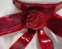 Close-up of a red glittery bow with a logo on a white background