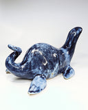 Ceramic sculpture of a sea monster akin to the Loch Ness Monster with dark blue glazing and light blue splattering.