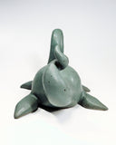 Ceramic sculpture of a sea monster akin to the Loch Ness Monster with a greenish blue glazing and a dotted finish.