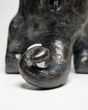 Close up of ceramic sculpture of a Godzilla's tail.