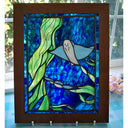 Stained glass panel with a shark design in a wooden frame.