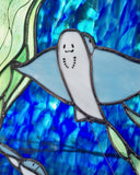 Stained glass artwork of a bat ray with a blue and green background