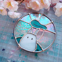 Stained glass artwork of a Chibi Totoro on a checkered background with cherry blossoms.